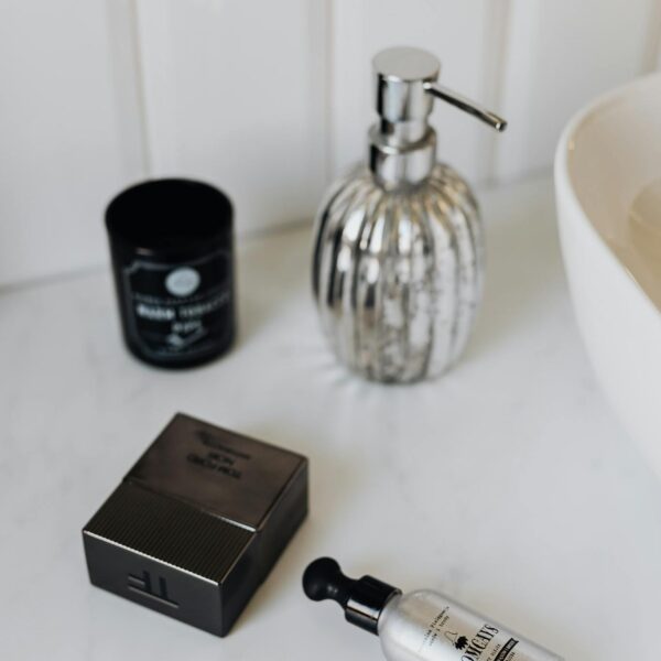 From above stylish set of male perfume and cosmetic products placed on marble surface near sink in bathroom